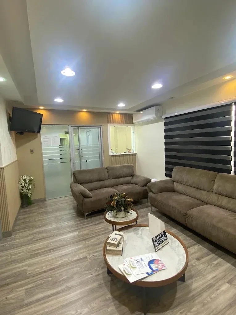 Sala de espera de la sucursal Zona Oriental con sofás, televisor y mesa de revistas