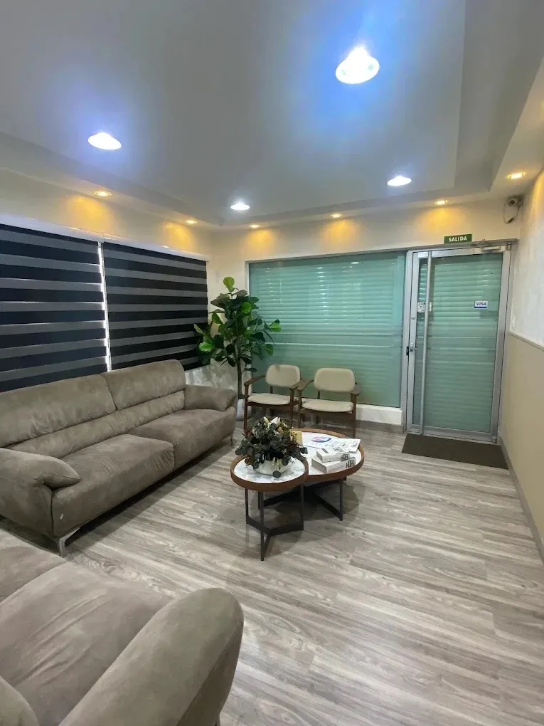 Sala de espera de la sucursal Zona Oriental con sofás y plantas junto a la salida